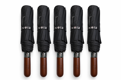 Five black umbrellas with brown wooden handles labeled 'ELEGANT NOIR' on a white background